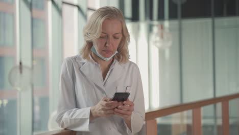 A-Blonde,-Middle-Aged-Female-Doctor-Sends-A-Mobile-Phone-Text-Message