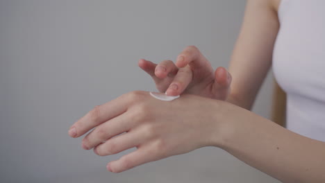 Detail-Of-A-Woman's-Hands-Applying-Cream-To-The-Back-Of-Her-Hands
