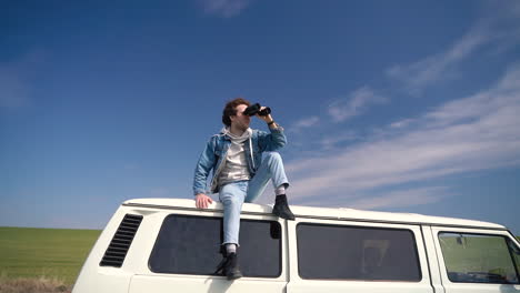 Young-Boy-Looks-Around-With-A-Pair-Of-Binoculars-On-The-Roof-Of-A-Caravan-1