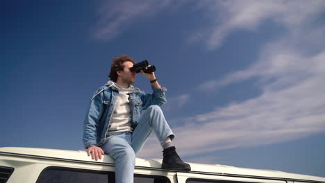 Young-Boy-Looks-Around-With-A-Pair-Of-Binoculars-On-The-Roof-Of-A-Caravan-3