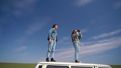 A-Young-Boy-And-Young-Girl-Look-Around-With-A-Pair-Of-Binoculars-On-The-Roof-Of-A-Caravan