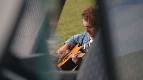 A-Young-Guy-With-Glasses-Plays-The-Guitar-In-The-Back-Of-A-Caravan-2