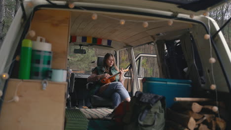 A-Young-Girl-With-Red-Hair-Plays-The-Ukulele-Inside-A-Caravan-In-The-Countryside
