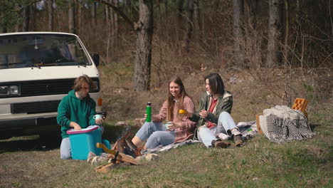 Two-Young-Girls-And-A-Young-Boy-Have-A-Good-Time-In-The-Forest-Having-A-Hot-Beverage