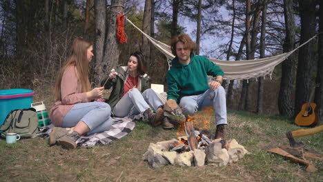 Two-Young-Girls-And-A-Young-Boy-Make-A-Bonfire-In-The-Forest
