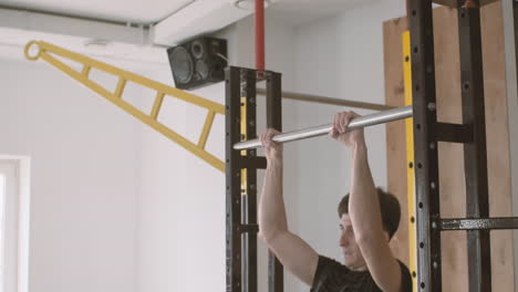 A-Sportive-Young-Man-Does-Pull-Ups-In-The-Gym