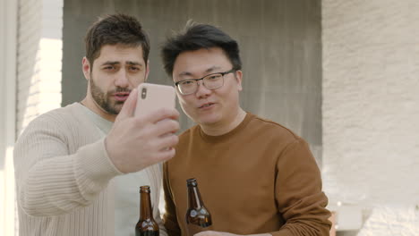 Ein-Junger-Typ-Und-Sein-Freund-Machen-Einen-Videoanruf,-Während-Sie-Bier-Trinken