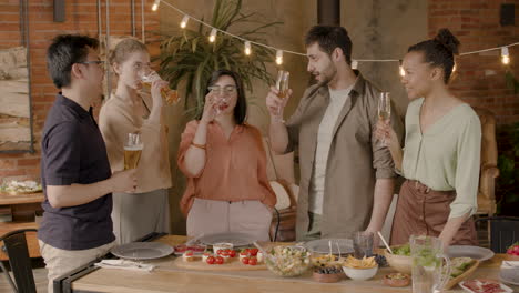 A-Multiethnic-Group-Of-Friends-Toasting-With-Their-Glasses-At-A-Dinner-Party