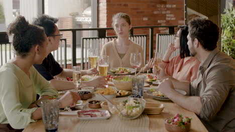 Junge-Frau-Erzählt-Ihrer-Multikulturellen-Gruppe-Von-Freunden-Bei-Einer-Dinnerparty-Eine-Geschichte