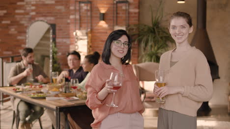Two-Young-Women-Talking-At-A-Dinner-Party