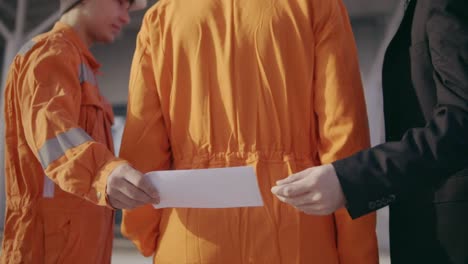 Man-In-A-Suit-Giving-To-The-Construction-Worker-In-Uniform-An-Envelope-With-Money-Bribe