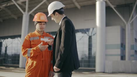 Man-In-A-Suit-Giving-To-The-Construction-Worker-In-Uniform-An-Envelope-With-Money-Bribe-1