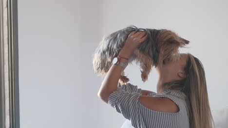 Woman-Lifting-Her-Dog-In-The-Air-And-Kissing-It