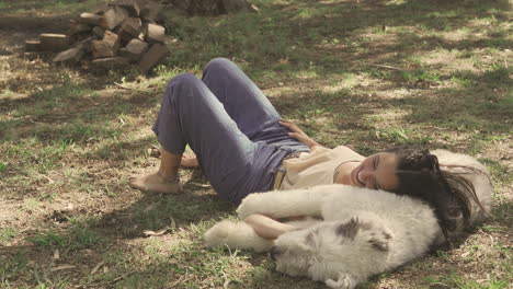 Young-Laughing-Woman-Lying-With-Her-Big-Dog-On-The-Grass