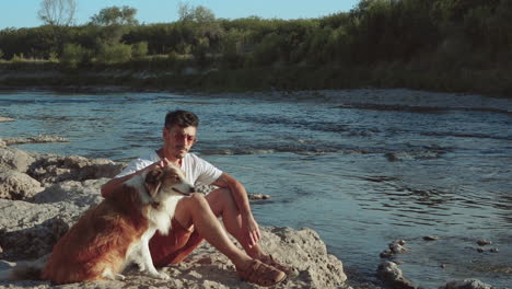 Young-Man-And-His-Dog-On-The-River-Bank