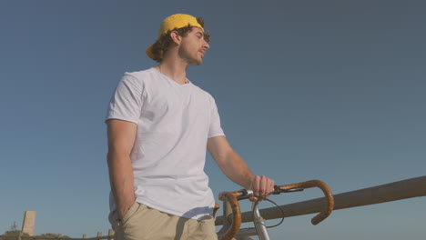 Hombre-Con-Bicicleta-Caminando-Por-El-Paseo-Marítimo