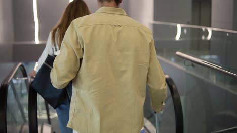 Rare-View-Of-Family-With-Yellow-Stylish-Suitcase-Going-Down-By-The-Escalator-With-Their-Pretty-Daughter-Hold-By-Mothers-Hand-At-The-Airport