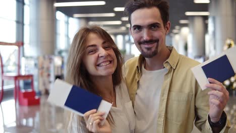 Aufgeregtes-Paar,-Das-In-Den-Urlaub-Fährt-Und-Am-Flughafen-Eine-Pass-Bordkarte-Hält