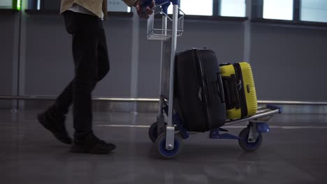 Unrecognizable-Male-Passenger-With-Luggage-Trolley-In-The-International-Airport