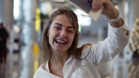 Portrait-Of-Happy,-Beautiful-American-Woman-Showing-Passport-With-Flight-Tickets-And-Waving-It