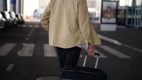 Close-Up,-Cropped-Shot-Of-Married-Man-With-The-Black-Baggage-Walking-To-The-Outside-Airport-Terminal-By-Road