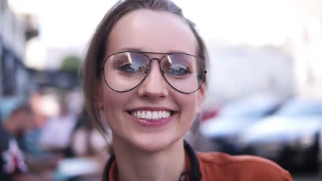 Gorgeous-Close-Up-View-Of-A-Young,-Blonde-Girl-Looking-At-The-Camera-And-Smiling,-Wearing-A-Stylish,-Modern-Glasses