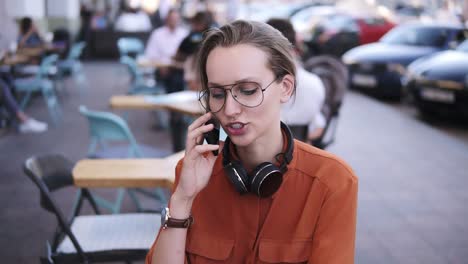 Mujer-De-Teléfono-Inteligente-Hablando-Por-Teléfono-Mientras-Está-Sentado-En-El-Café