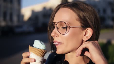 Side-View-Footage-Of-A-Attractive-Girl-Eating-Big-White-Ice-Cream-Outside-On-The-Street