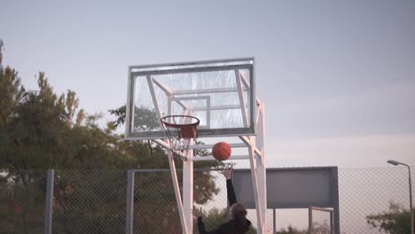 Rückseitenaufnahmen-Einer-Jungen-Basketballspielerin,-Die-Draußen-Auf-Dem-örtlichen-Platz-Trainiert-Und-Trainiert