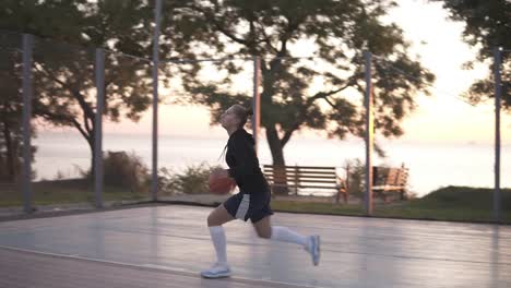 Handheld-Aufnahmen-Einer-Jungen-Basketballspielerin,-Die-Draußen-Auf-Dem-örtlichen-Platz-Trainiert-Und-Trainiert