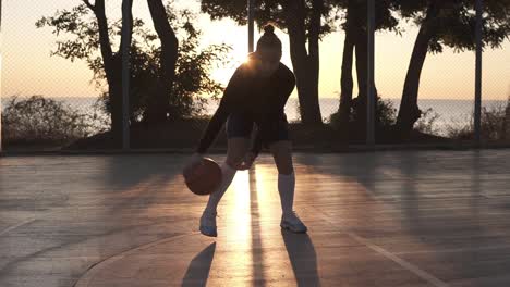 Joven-Jugadora-De-Baloncesto-Regateando-Y-Practicando-La-Habilidad-De-Manejar-El-Balón-En-La-Cancha