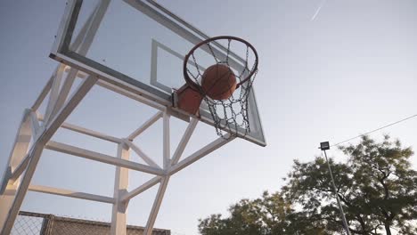 Basketballspielerin-Im-Morgenlicht-Auf-Einem-Professionellen-Platz,-Der-Mit-Ball-Läuft-Und-Ball-Ins-Netz-Wirft