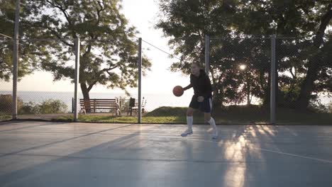 Seitenaufnahmen-Einer-Jungen-Basketballspielerin,-Die-Draußen-Auf-Dem-örtlichen-Platz-Trainiert-Und-Trainiert