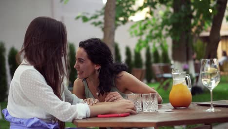 People,-Communication-And-Friendship-Concept-Smiling-Young-Women-Drinking,-Talking-At-Outdoor-Cafe,-Brunette-Sharing-Good-News-Or-Gossips