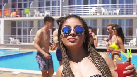 Young-Beautiful-Girl-With-Dreads-And-Sunglasses-Coming-Clother-To-Camera-While-Dancing-On-The-Pool-Party
