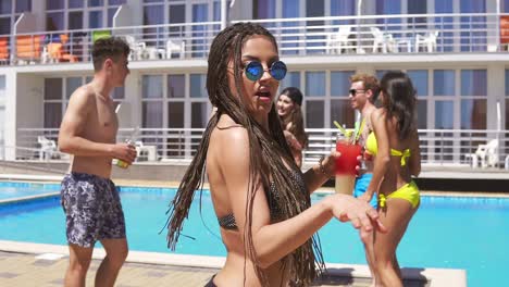 Young-Beautiful-Girl-With-Dreads-And-Sunglasses-Coming-Clother-To-Camera-While-Dancing-On-The-Pool-Party-1