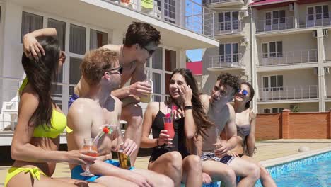 Glückliche-Gruppe-Junger-Freunde,-Die-Im-Sommer-Mit-Cocktails-Abhängen-Und-Am-Rand-Des-Pools-Plaudern-2