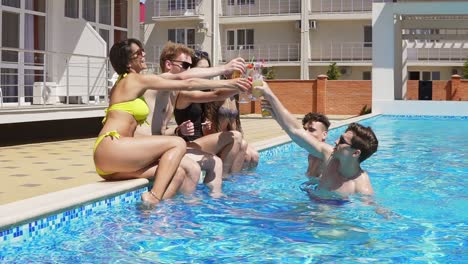 Glückliche-Gruppe-Junger-Freunde,-Die-Im-Sommer-Mit-Cocktails-Abhängen-Und-Am-Rand-Des-Pools-Plaudern-3