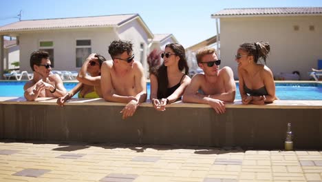 Young-Attractive-People-Hanging-Out-At-The-Side-Of-The-Pool-In-The-Summertime