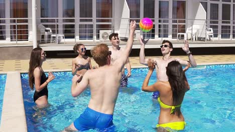 Group-Of-Young-Friends-Playing-Volley-Ball-In-The-Swimming-Pool-1