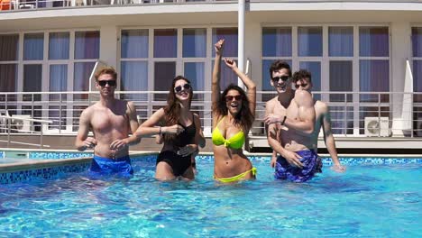 Happy-Young-Cheerful-Friends-Dancing-And-Having-Fun-In-The-Pool-Cooling-Off-In-The-Water-On-A-Hot-Summer-Day