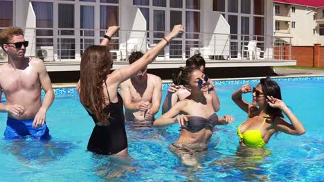 Happy-Young-Cheerful-Friends-Dancing-And-Having-Fun-In-The-Pool-Cooling-Off-In-The-Water-On-A-Hot-Summer-Day-1