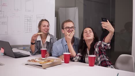 Verschiedene-Glückliche-Mitarbeiter-Essen-Während-Der-Büropause-Pizza-Und-Machen-Glücklich-Alle-Zusammen-Selfie