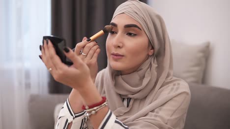 Muslim-Woman-Doing-Makeup-On-Her-Face-With-Brush