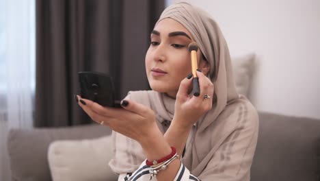 Side-View-Of-Muslim-Woman-Doing-Makeup-On-Her-Face-With-Brush,-Applying-Eyeshadows