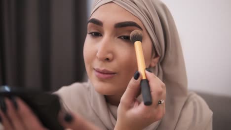 Close-Up-Of-Muslim-Woman-Doing-Makeup-On-Her-Face-With-Brush,-Applying-Eyeshadows