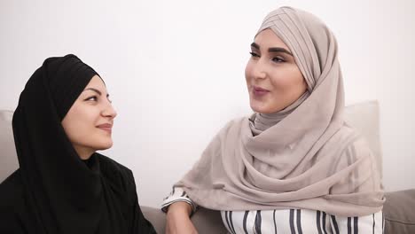 Two-Muslim-Woman-Sitting-On-Sofa-Relaxing-And-Talking