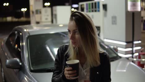 Smiling-Woman-Leaning-On-The-Car-And-Holding-Black-Paper-Cup