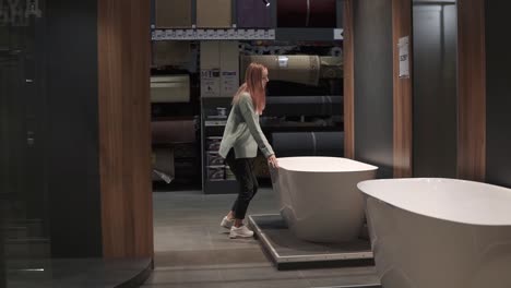 Woman-Chooses-A-New-Bath-In-An-Interior-Design-Store