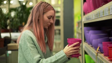 Woman-Choosing-Colorful-Pot-For-Home-Plants-From-Shelves-Of-A-Flower-Shop
